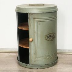 an old green metal cabinet with two round shelves on the front and one door open