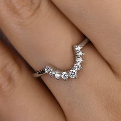 a woman's hand with a diamond ring on top of her finger and the bottom half of her wedding band