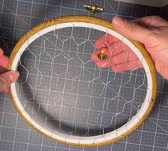 two hands are working on an embroidery project