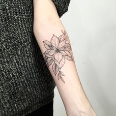 a woman's arm with a flower tattoo on the left side of her arm