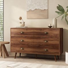 a large wooden dresser sitting in a living room next to a painting on the wall