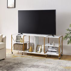 a living room with a large television on top of a wooden entertainment center next to a white couch