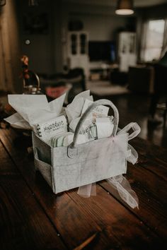 a white basket filled with baby items on top of a wooden table