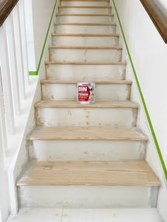 a can of dog food sitting on the bottom of a set of stairs with green painted handrails