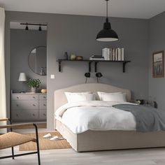 a bedroom with gray walls and white bedding