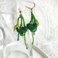 Green Heart and Leaves Beaded Earrings Beautify your style with these Green Heart and Leaves Beaded Earrings. Crafted with a unique green heart design, these handmade earrings feature a stunning beaded appearance. An ideal addition to your wardrobe, these earrings are perfect for any special occasion. Detail: Length of bracelet - around 15cm, adjustable for extra 5cm; thickness of bracelet - around 20mm Material: Beads - Acrylic; Stud - sterling silver; Buckle and chain - gold-plated bronze;  Note: the Green Heart and Leaves Beaded Earrings are handmade locally in the UK, each pieces would vary slightly in detail.  About postage: Standard postage When choosing standard postage, we assume this order is for yourself, or you will wrap the item yourself before giving it out as a gift (the comp Handmade Green Heart Earrings As Gift, Handmade Green Heart Earrings For Gift, Green Heart-shaped Bohemian Earrings, Green Heart Beads Earrings For Gift, Green Earrings With Heart Beads For Gifts, Green Beaded Chain Earrings, Green Beaded Earrings As Gift, Green Beaded Chain Earrings Gift, Green Beaded Chain Earrings With Round Beads