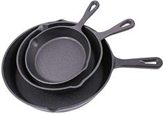 three cast iron pans are stacked on top of each other, one is empty