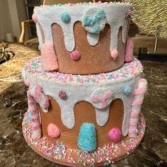 three tiered cake decorated with sprinkles and frosting