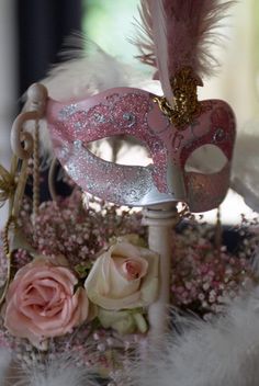 a masquerade with feathers and flowers on a table