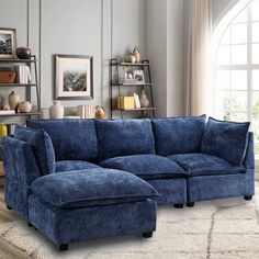 a living room with a blue sectional couch and ottoman in it's center area