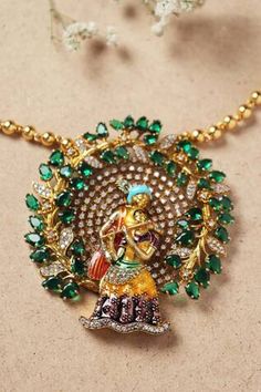 Gold toned long pendant necklace featuring Radha Krishna design with stone and Moissanite embellishments Green Diamond Temple Jewelry Necklace, Hand Set Emerald Pendant Necklace, Fusion Style Necklaces With Stone Setting, Hand Set Pendant Necklace In Fusion Style, Exquisite Hand Set Pendant Necklace, Temple Jewelry Pendant With Stones, Hand Set Fusion Pendant Necklaces, Hand Set Fusion Pendant Necklace, Luxury Hand Set Temple Necklace As Gift