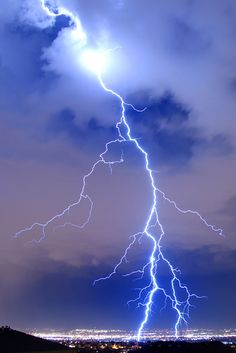 a lightning bolt is seen in the sky over a city