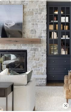 a living room filled with furniture and a fire place next to a book shelf covered in books