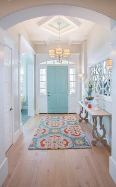 a blue door is in the middle of a hallway with white walls and wood floors