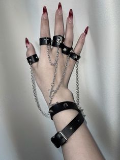 This uniquely designed bracelet features an integrated ring, connected by a stylish chain that adds a touch of avant-garde elegance. The bracelet is adorned with stud embellishments, while the ring showcases intricate decorations including skeleton motifs, crosses, and additional studs.  Please note that the price includes one bracelet with rings.  Ring Diameters: - Thumb, Index, and Middle Fingers: 6.5 cm - Ring and Pinky Fingers: 6 cm Punk Pastel, Punk Style Outfits, Punk Skirt, Pastel Punk, Heart Shaped Bag, Gothic Bag, Middle Fingers, Casual Goth, Gothic Shoes