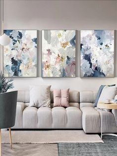 a living room with three paintings on the wall