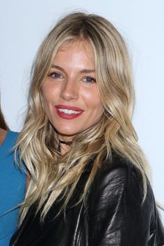 a woman with blonde hair wearing a black leather jacket