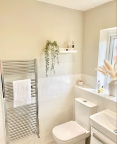 a bathroom with a white toilet next to a sink and a radiator in it