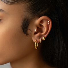 Small thick twisted rope hoop earrings are the perfect everyday earrings. Easy to put on and take off. Gold Vermeil Hypoallergenic, lead and nickel free Height 0.55in(14mm) x Width 0.14in(3.5mm) Latch, Click to close #E464-G Gold Earring Layout, Mejuri Piercing, Three Earlobe Piercings, Minimalist Piercings Ear, Ear Gold Jewellery, Peircings Women Idea, Classy Earring Stack, 3 Earrings Piercing Ideas, Classy Gold Earrings