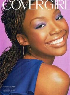 a magazine cover with a woman smiling and wearing earrings on her head, in front of a purple background