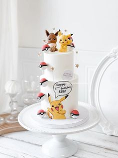 a pokemon themed birthday cake with pikachu figurines on top