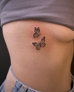 a woman's stomach with two butterflies on it and the bottom part of her abdomen