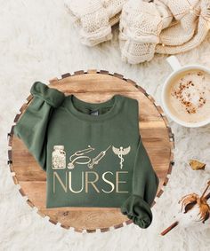 a green shirt that says nurse next to a cup of coffee