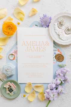 the wedding stationery is surrounded by flowers and jewelry