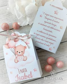 a card with a teddy bear on it next to some pink eggs and white flowers