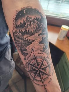 a man with a compass tattoo on his arm