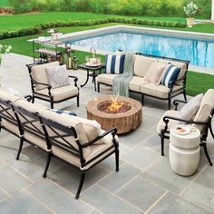 an outdoor living area with chairs, tables and a fire pit in front of a swimming pool