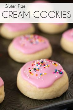 cookies with pink icing and sprinkles on a baking sheet