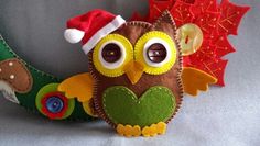 an owl with a santa hat is sitting on a crescent ornament made out of felt