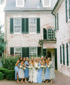 a group of women standing next to each other in front of a building