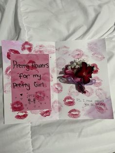 a piece of paper with writing on it next to a flower and handprints