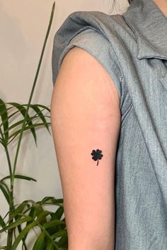 a small four leaf clover tattoo on the left arm