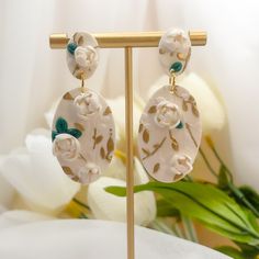 Step into summer with our exquisite Evangeline Earrings, where artistry and elegance bloom. Crafted from polymer clay, each earring showcases intricate 3D floral designs adorned with delicate gold leaf accents, capturing the essence of a summer garden in full bloom. The hypoallergenic gold filled posts ensure comfort for all-day wear, making them perfect for summer outings, weddings, and special events where you want to shine. Elegant Floral Print Drop Earrings, Elegant Flower Earrings With Floral Print For Gift, Elegant Floral Print Flower Earrings For Gift, Elegant Floral Print Flower Earrings As Gift, Gold Jewelry With 3d Flowers In Polymer Clay, Gold Polymer Clay Jewelry With 3d Flowers, Elegant Floral Print Earrings, Handmade Gold Flower Earrings In Polymer Clay, Gold Flower-shaped Polymer Clay Earrings