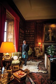 a man standing in a living room next to a lamp