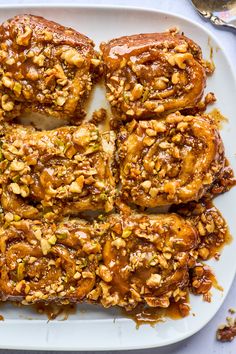 a white plate topped with pastries covered in nuts