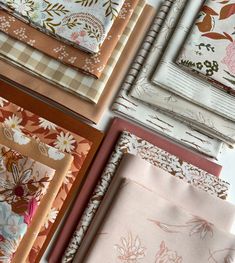 many different types of fabric laid out on top of each other, including pinks and browns