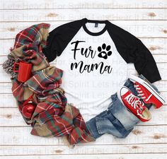 a black and white shirt with the words fur mama on it next to some plaid blankets