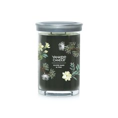 yankee candle with white flowers and leaves on the front, in a black glass jar