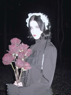 a woman is holding roses in her hands at night, wearing a bonnet and black dress