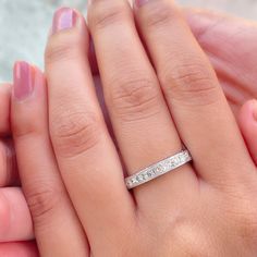 a woman's hand with a wedding band on it