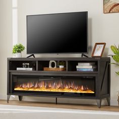 an entertainment center with a flat screen tv and fire flames in the bottom part of it