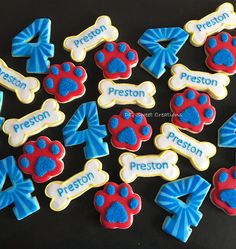 decorated cookies with blue, red and white frosting on a black tablecloth that says preston