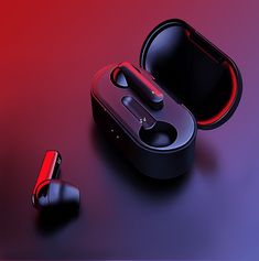 two earphones sitting next to each other on a red and purple surface with an electronic device in the background