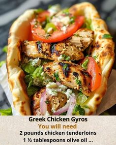 a chicken gyro with tomatoes, lettuce and onions on it in a pita bread