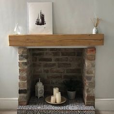 a fire place with candles and pictures on the mantle