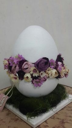 an egg with flowers in it sitting on a table